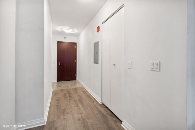 corridor featuring electric panel and light hardwood / wood-style flooring