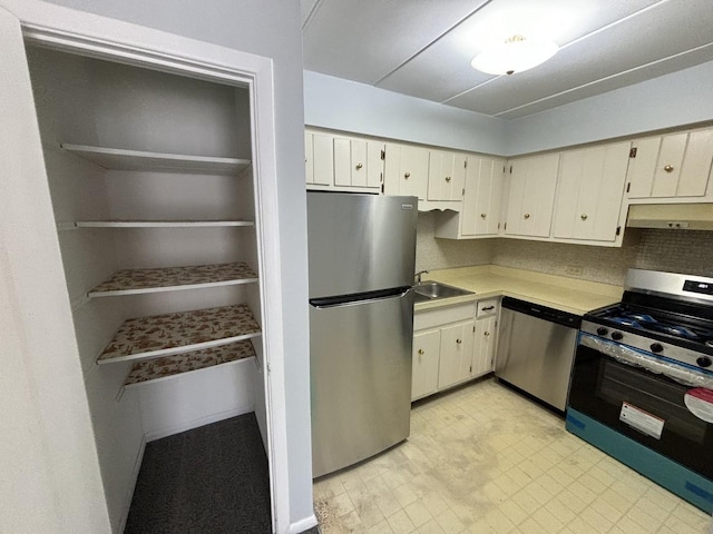 kitchen with sink, cream cabinets, appliances with stainless steel finishes, and tasteful backsplash