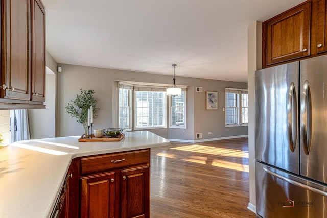 kitchen featuring a peninsula, plenty of natural light, light countertops, and freestanding refrigerator