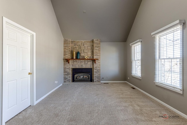 unfurnished living room with high vaulted ceiling, carpet, baseboards, and a large fireplace