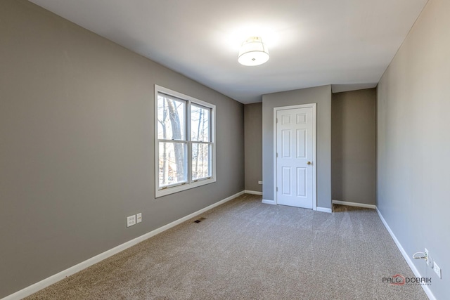 unfurnished room featuring visible vents, baseboards, and carpet floors