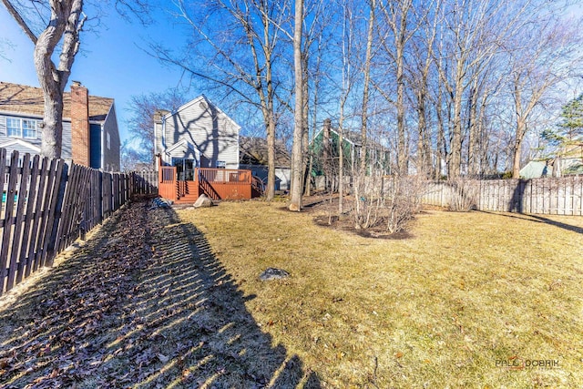 view of yard with a wooden deck and a fenced backyard