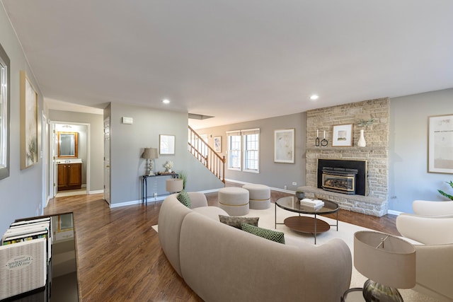 living area featuring wood finished floors, recessed lighting, stairway, a large fireplace, and baseboards