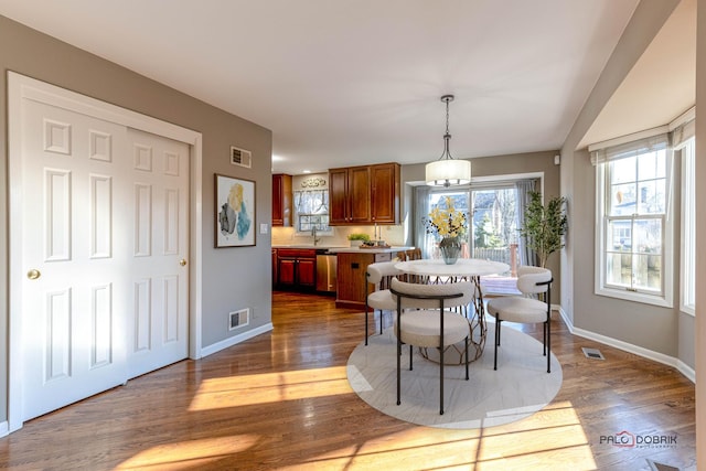 dining room featuring visible vents, baseboards, and dark wood-style flooring