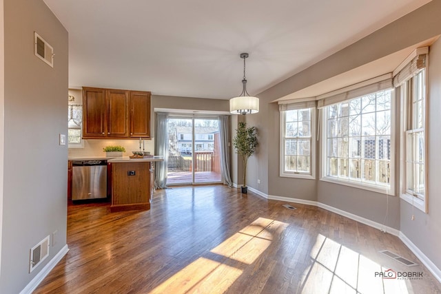 unfurnished dining area featuring dark wood finished floors, baseboards, and visible vents