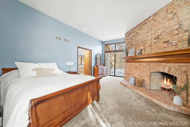 bedroom featuring access to exterior, carpet floors, and a brick fireplace