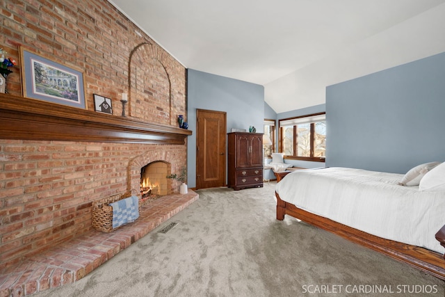 carpeted bedroom with a fireplace and vaulted ceiling