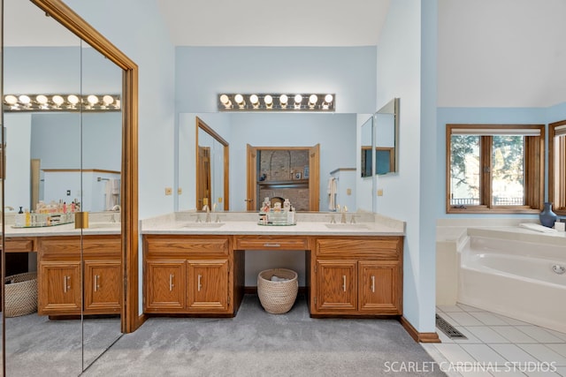 bathroom featuring vanity, tile patterned flooring, and a bathtub