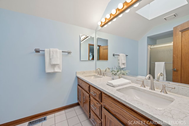 bathroom featuring tile patterned flooring, vanity, an enclosed shower, and a skylight