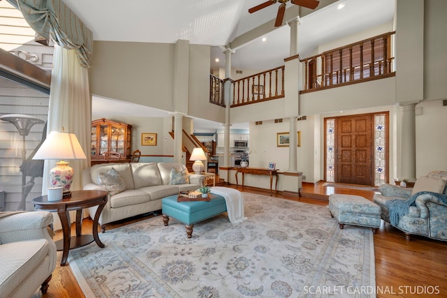 living room featuring ceiling fan, hardwood / wood-style floors, and ornate columns