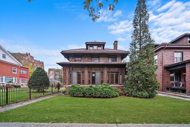 view of front of home featuring a front lawn and a sunroom