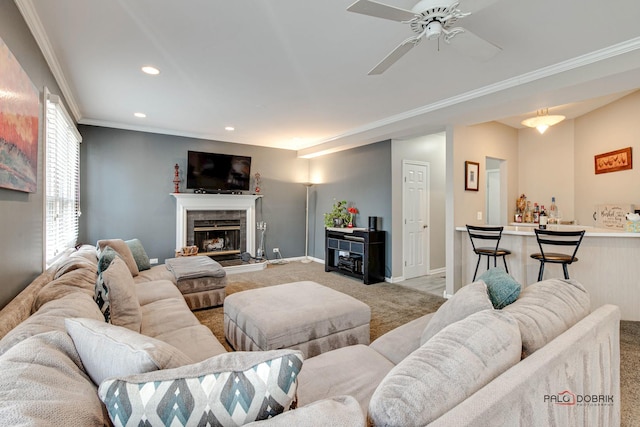 carpeted living room with ornamental molding, ceiling fan, and a fireplace