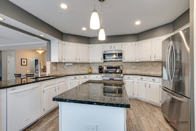 kitchen with white cabinetry, sink, stainless steel appliances, and a center island