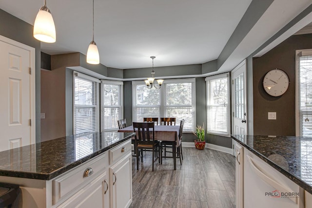 kitchen featuring pendant lighting, white cabinetry, dark stone counters, and dishwasher