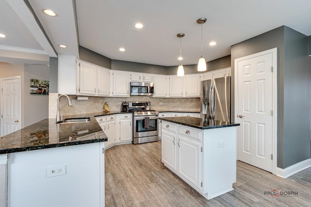 kitchen featuring white cabinetry, appliances with stainless steel finishes, a center island, and sink