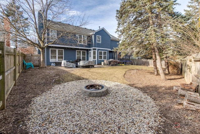 back of property with a trampoline and a fire pit