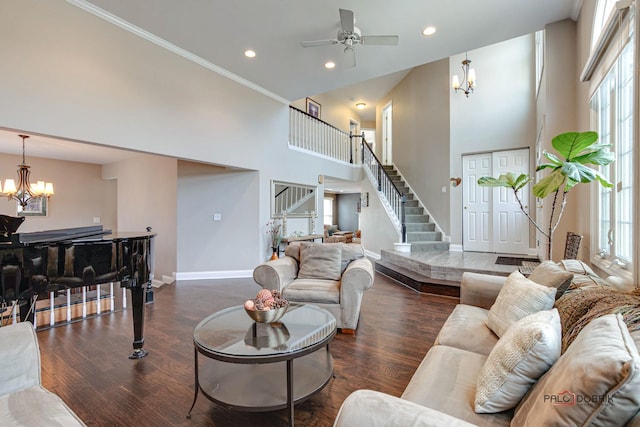 living room featuring ornamental molding, a healthy amount of sunlight, dark hardwood / wood-style floors, and a high ceiling