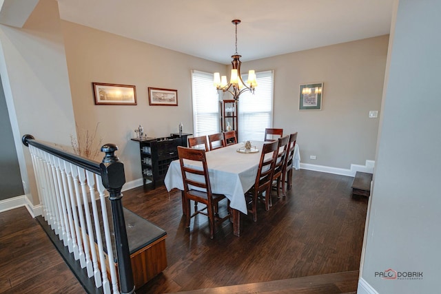 dining space with dark hardwood / wood-style flooring and a chandelier