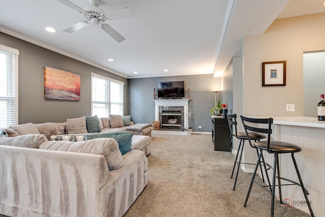 carpeted living room with ornamental molding, ceiling fan, and bar area