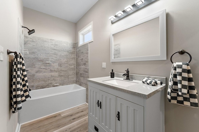 bathroom featuring vanity, hardwood / wood-style floors, and tiled shower / bath combo