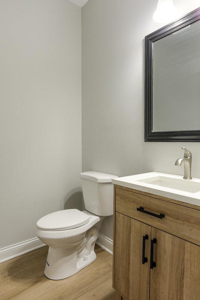 bathroom with wood-type flooring, toilet, and vanity