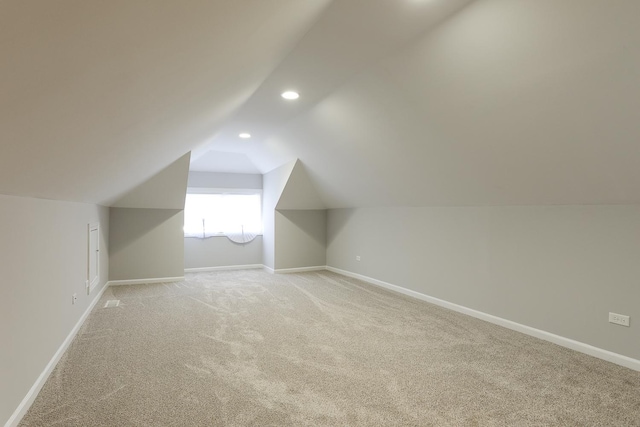 bonus room featuring light carpet and vaulted ceiling