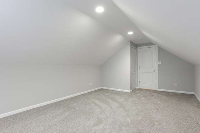 additional living space featuring lofted ceiling and carpet flooring