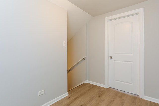 staircase featuring wood-type flooring and lofted ceiling