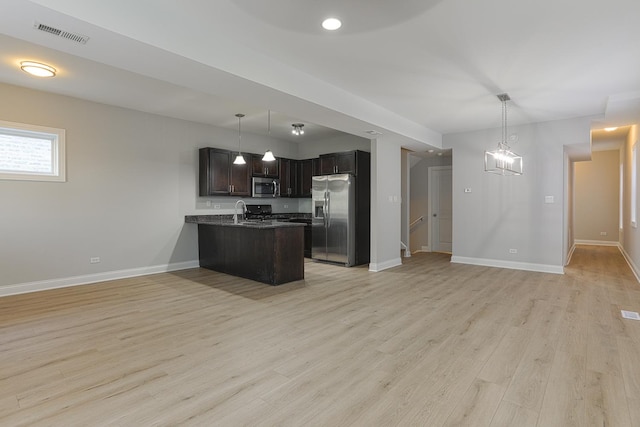 kitchen with hanging light fixtures, dark brown cabinets, light hardwood / wood-style flooring, kitchen peninsula, and stainless steel appliances