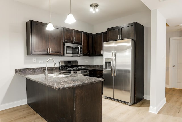 kitchen with sink, pendant lighting, dark brown cabinetry, and stainless steel appliances