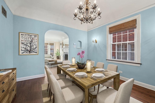 dining area with a notable chandelier and dark hardwood / wood-style flooring