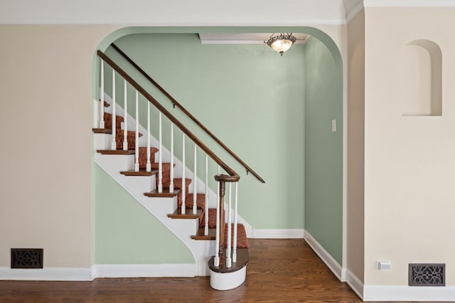 stairs with hardwood / wood-style flooring and ornamental molding