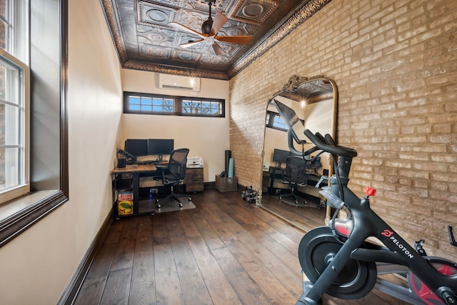 office area with hardwood / wood-style flooring, brick wall, a wall unit AC, and a wealth of natural light