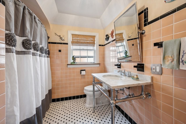 bathroom with sink, tile walls, a shower with curtain, tile patterned floors, and toilet