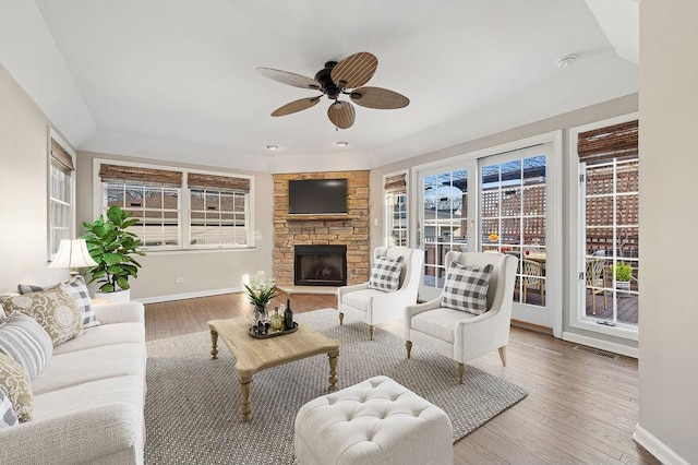 living room featuring hardwood / wood-style flooring, a fireplace, and ceiling fan