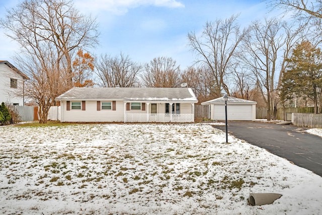 ranch-style house featuring a garage, an outbuilding, and covered porch