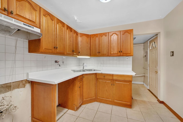 kitchen featuring sink, backsplash, light tile patterned floors, and kitchen peninsula