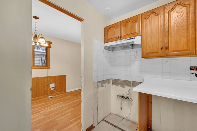 kitchen with decorative light fixtures, decorative backsplash, and light tile patterned floors