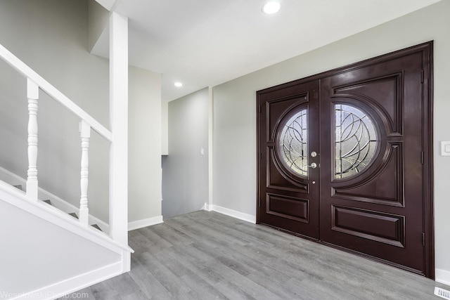 entrance foyer with french doors and light hardwood / wood-style flooring