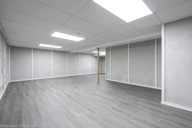 basement with wood-type flooring and a drop ceiling