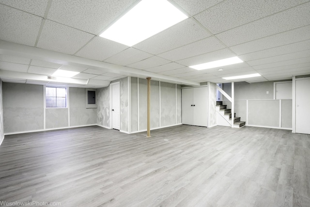 basement featuring wood-type flooring and a drop ceiling