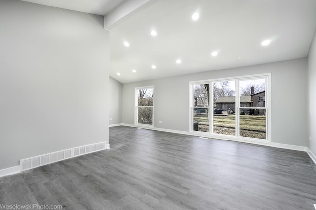 unfurnished living room featuring dark hardwood / wood-style flooring and a wealth of natural light