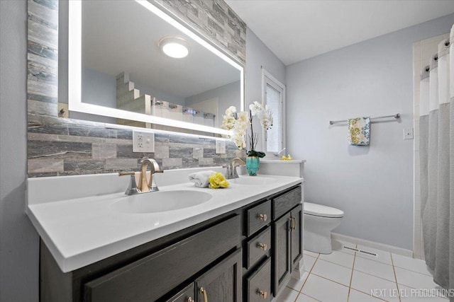 bathroom featuring tasteful backsplash, vanity, tile patterned flooring, and toilet