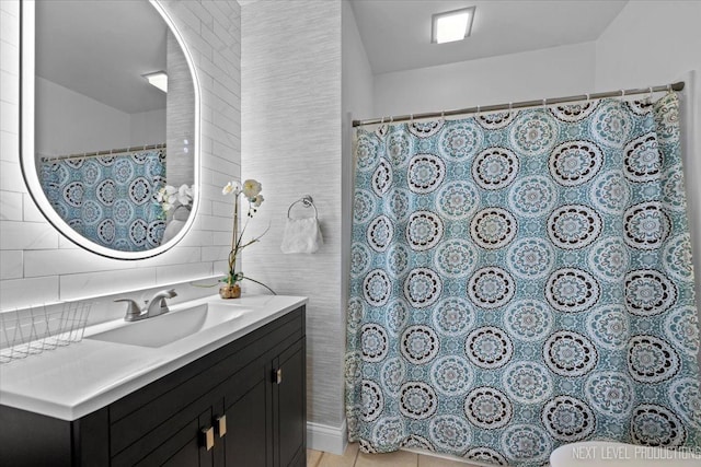 bathroom with vanity, tile walls, and backsplash