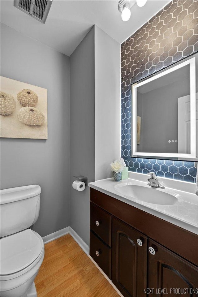 bathroom featuring vanity, toilet, and hardwood / wood-style floors