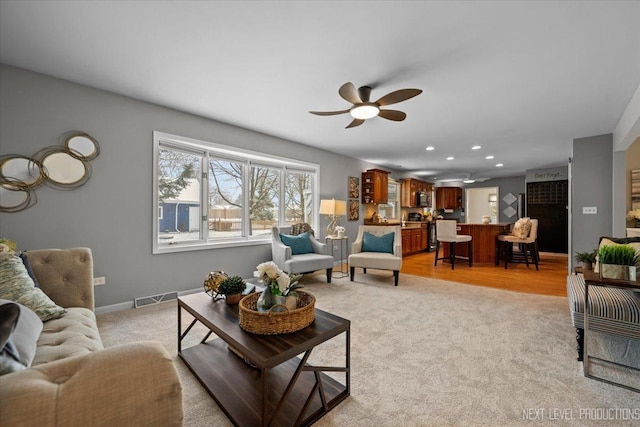 carpeted living room with ceiling fan