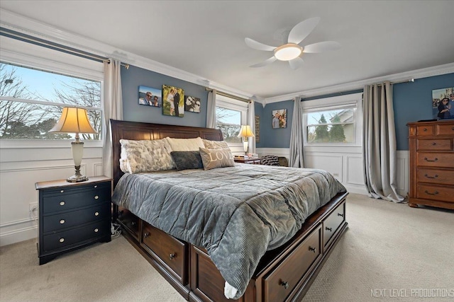 bedroom with light colored carpet, ornamental molding, and ceiling fan