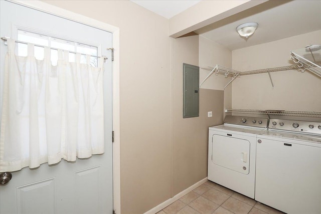 clothes washing area featuring electric panel, washing machine and dryer, and light tile patterned floors