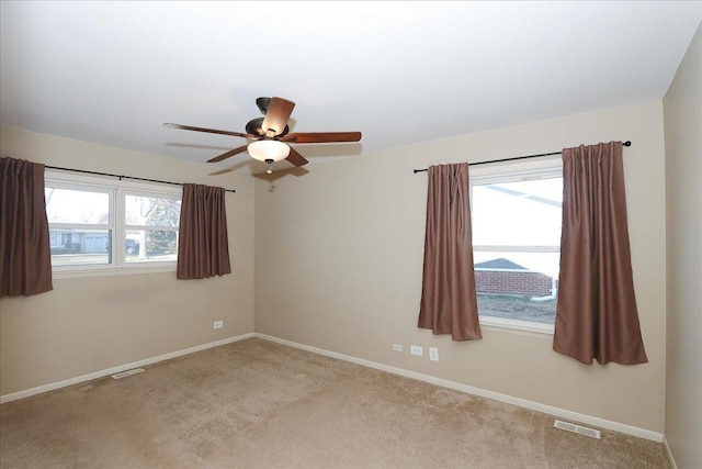 carpeted spare room featuring ceiling fan