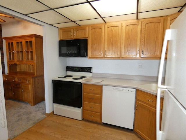 kitchen with sink, white appliances, and light hardwood / wood-style flooring